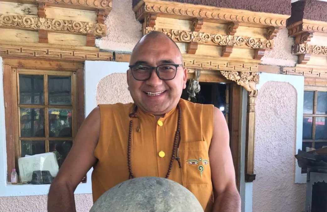 Khenpo Gyaltsen lifting a big rock